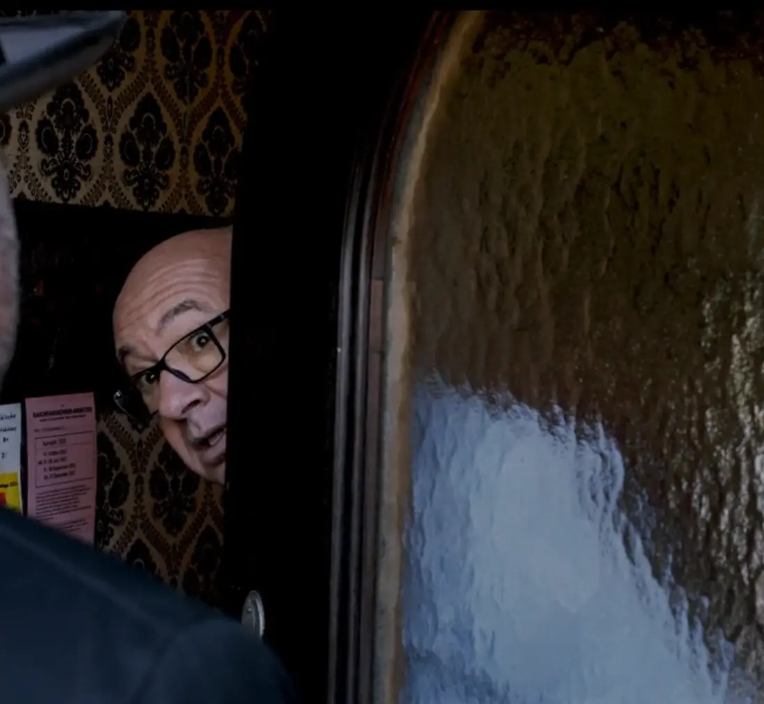 Älterer Bauer vor einem Bergbauernhof in dramatischer Stimmung